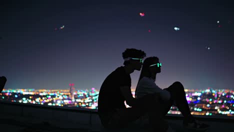 stylish couple wearing illuminated glasses perched on urban rooftop, overlooking sparkling los angeles nightscape with vibrant aerial elements floating overhead