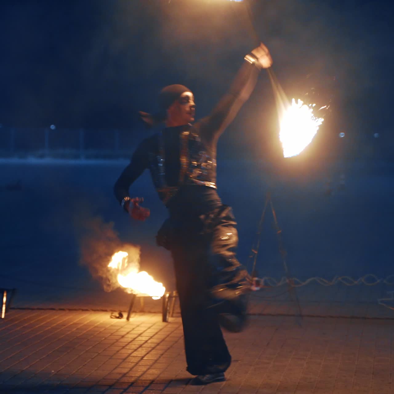 Pareja de bailarines moviéndose con palos de fuego. Artistas de espectáculos de fuego al aire libre de noche.