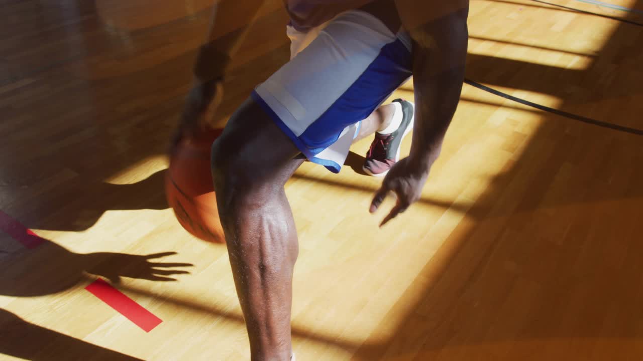 Player bouncing basketball dribbling between-legs move and resuming drill on court for training