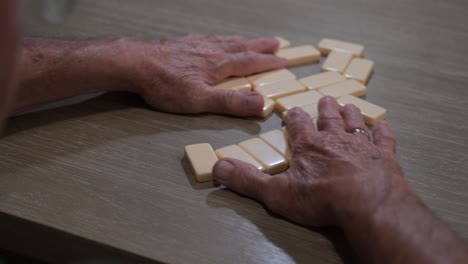 älterer-Mann-Mischt-Dominosteine-In-Einem-Late-Night-Spiel