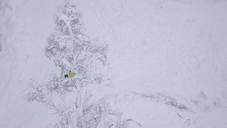 man shovels snow in winter, top down aerial view