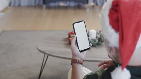 middle aged caucasian man using smartphone with blank screen at christmas at home, slow motion