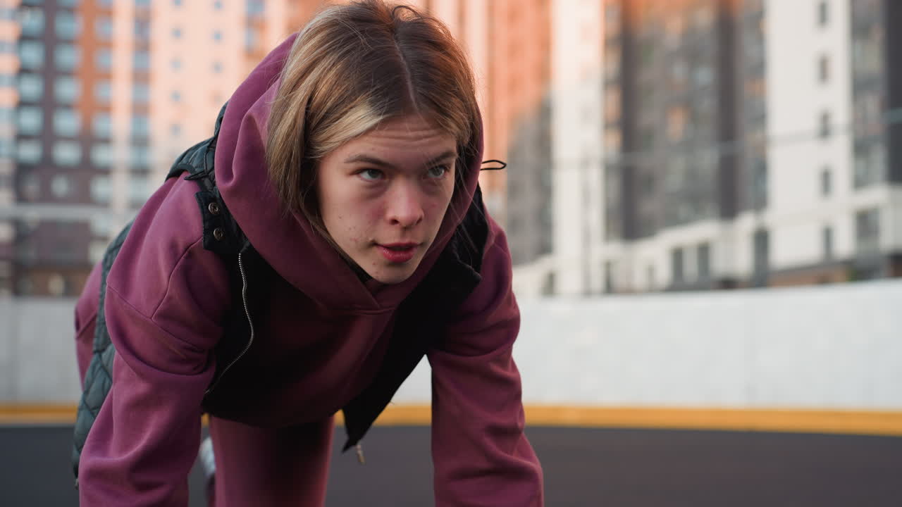 Calm focused lady doing foot crawl exercise on urban court floor with hands on ground moving legs simultaneously to build core strength stability mobility and dynamic coordination during city workout