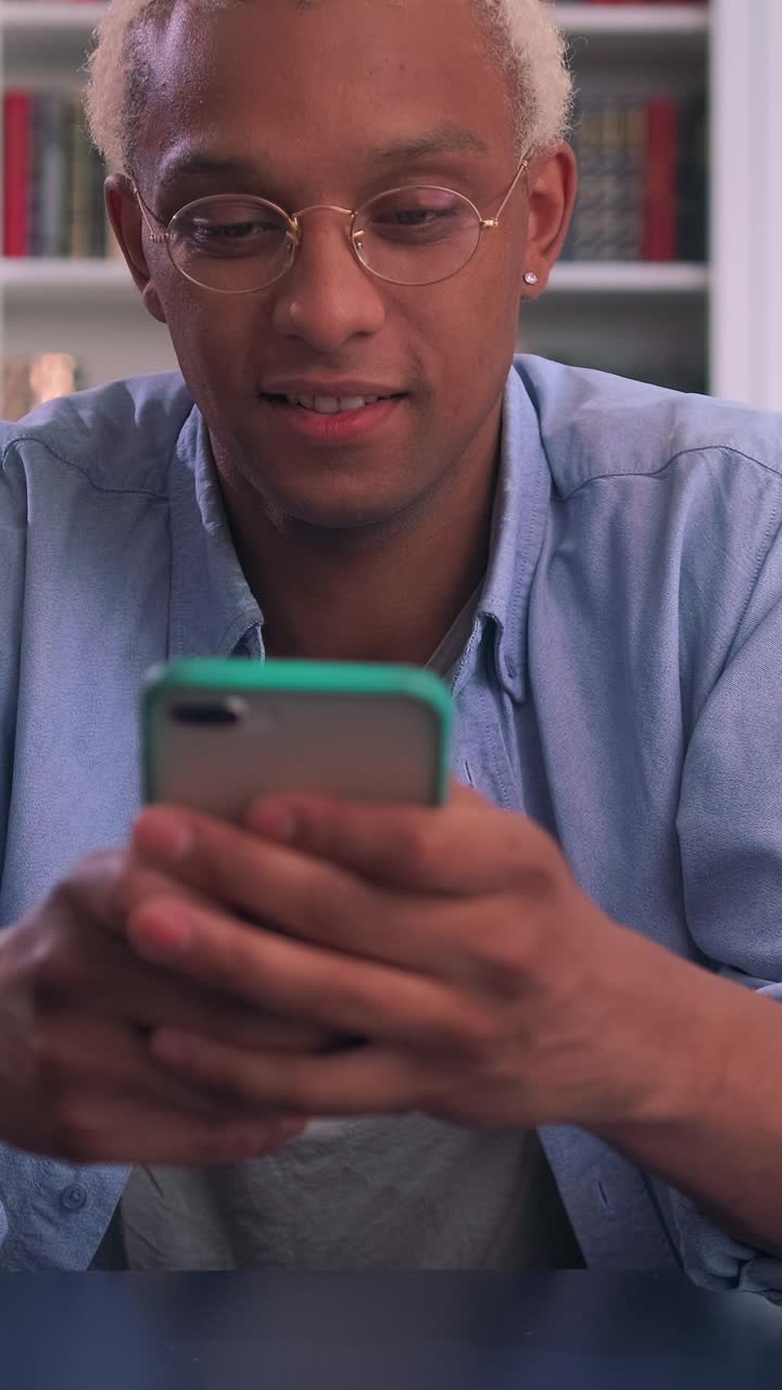 Young african american man engages with smartphone indoors