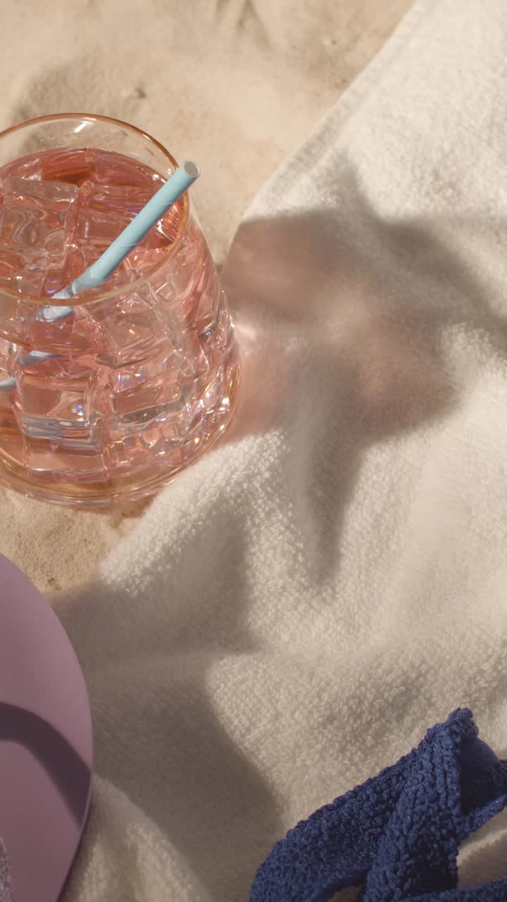 Vertical Video Summer Holiday Concept Of Flip Flops With Cold Drink On Sand Background With Tree Shade Shadow 1