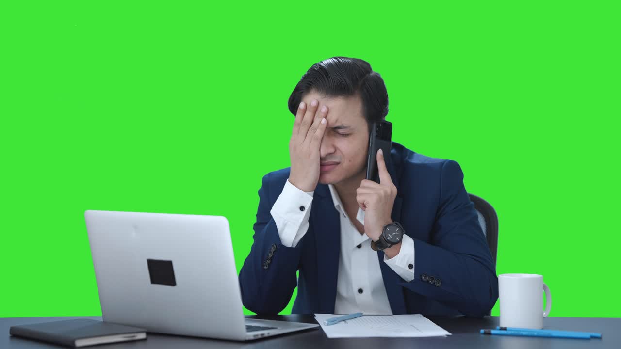 Gestresster indischer Manager telefoniert vor Green Screen.
