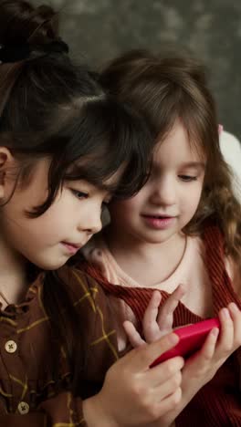 two young girls looking at a phone