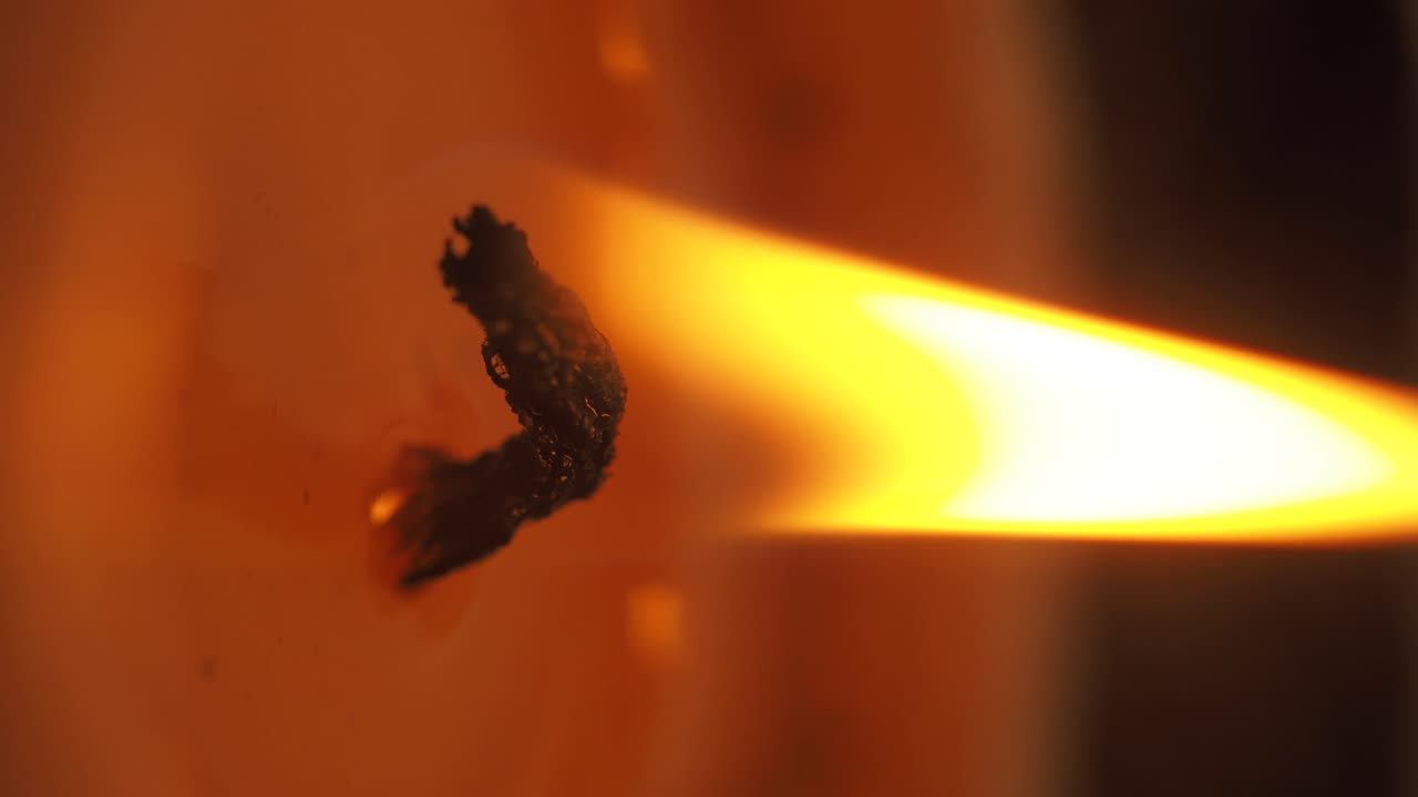 Close-up of a burning candle wick and bright flame