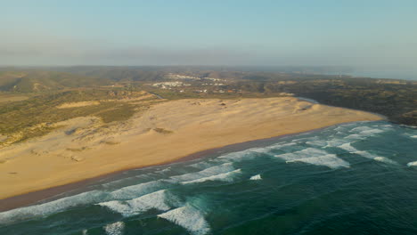 Vista-Aérea-De-La-Playa-De-Bordeira-Con-Dunas-Y-Olas-Rompiendo-En-La-Costa-De-La-Costa-Oeste-De-Portugal-Durante-La-Hora-Dorada.