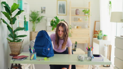 a sad girl sits sadly at her desk after returning from school