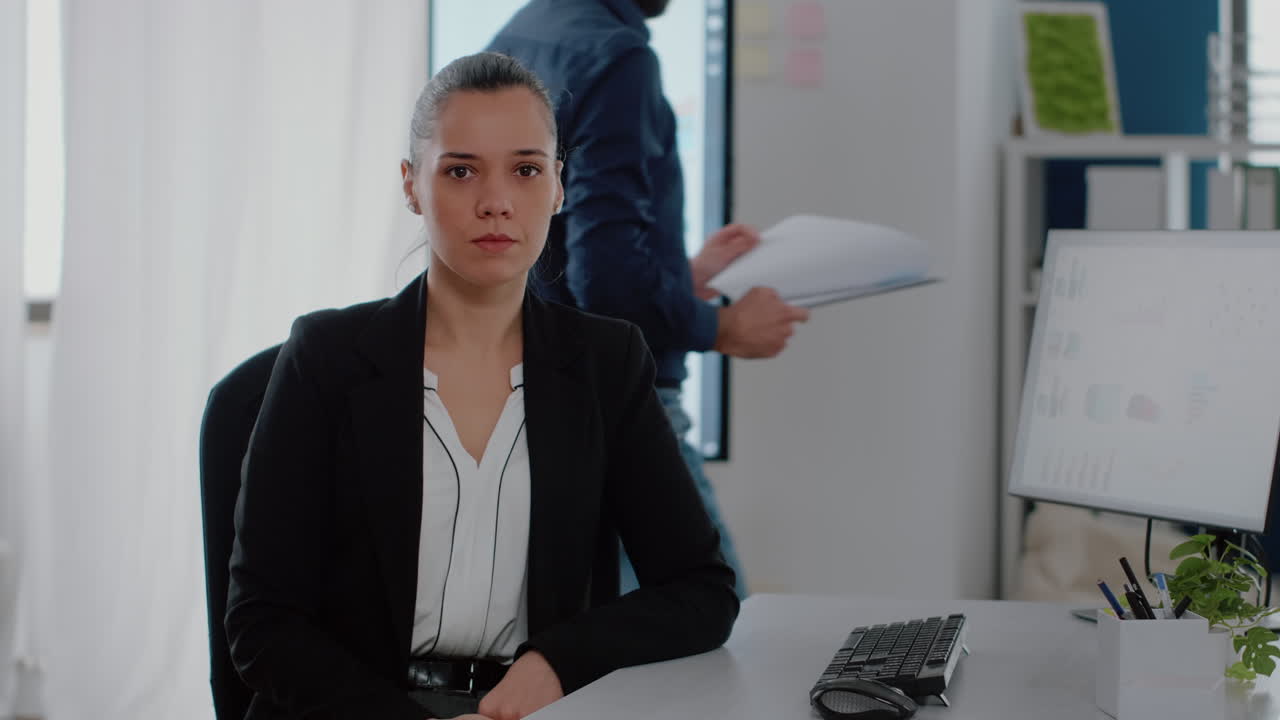 Portrait of corporate worker sitting at desk with computer