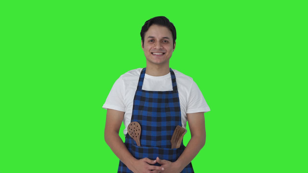 Cuoco indiano felice che sorride alla telecamera su schermo verde