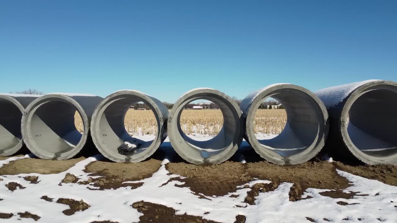 Beton Boruların İçinden Karla Kaplı Buğday Tarlasına Bakılan Drone Çekimi