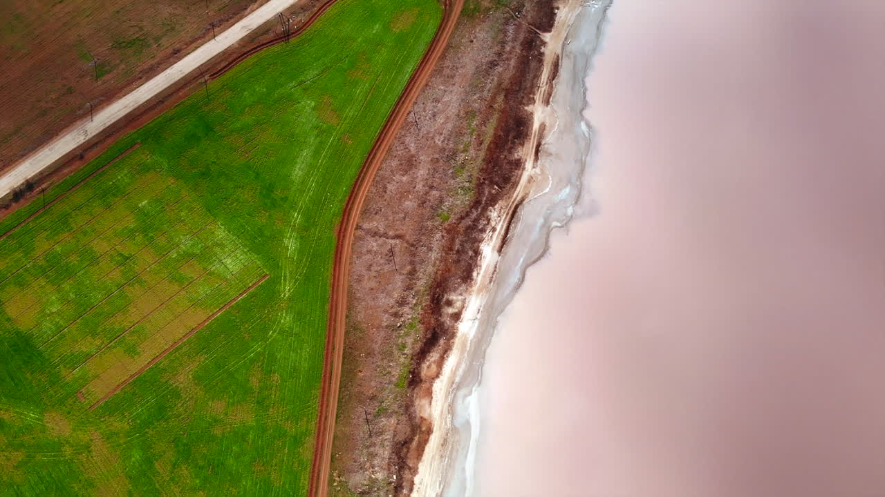 Aerial View of Pink Lake and Green Field