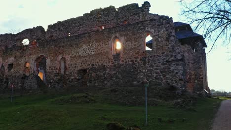 sunlight passing through window of rauna castle ruins in rauna, latvia. - zoom in