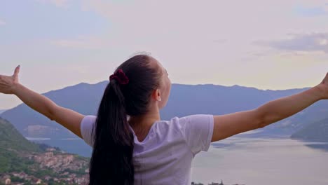 una chica feliz en la cima de una montaña.