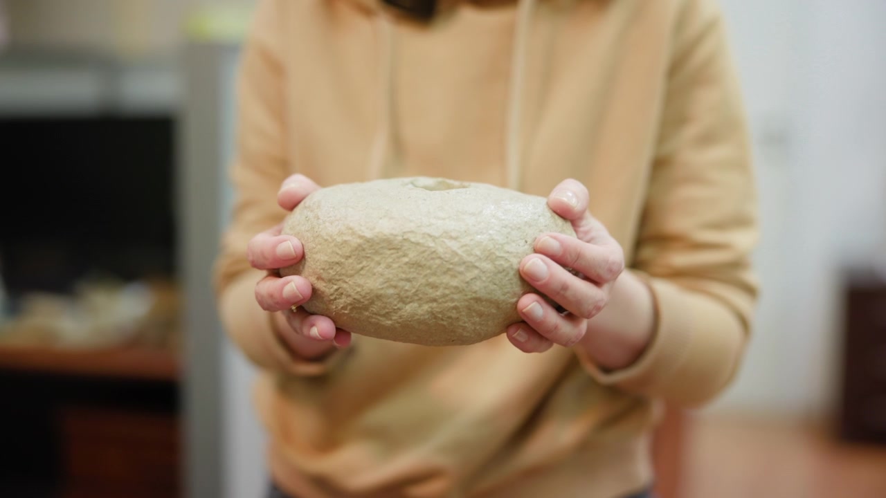Closeup Of Hands Holding Dough, Home Baker Cradling Round Unbaked Loaf In Cozy Kitchen, Flourdusted Fingers, . Media