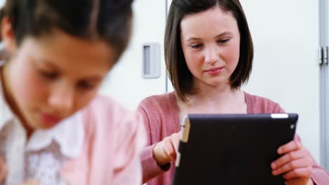 niña de escuela que usa una tableta digital en el aula