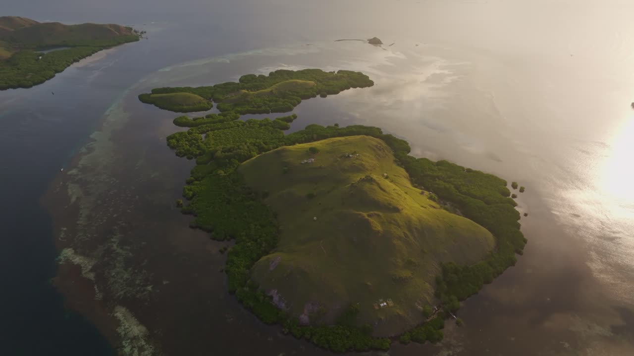 Imagem de drone de um nascer do sol dourado sobre uma ilha remota, Mar de Flores, Indonésia.