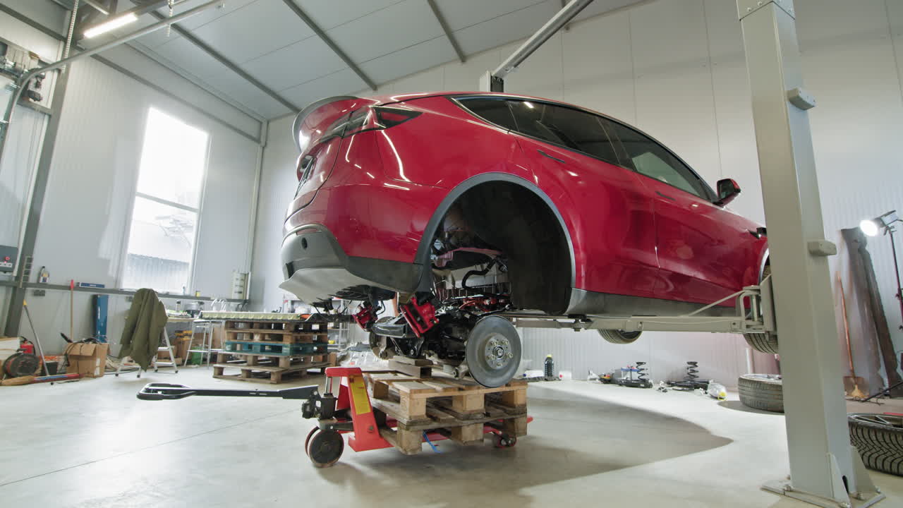 красная электрическая машина на ремонте в гараже