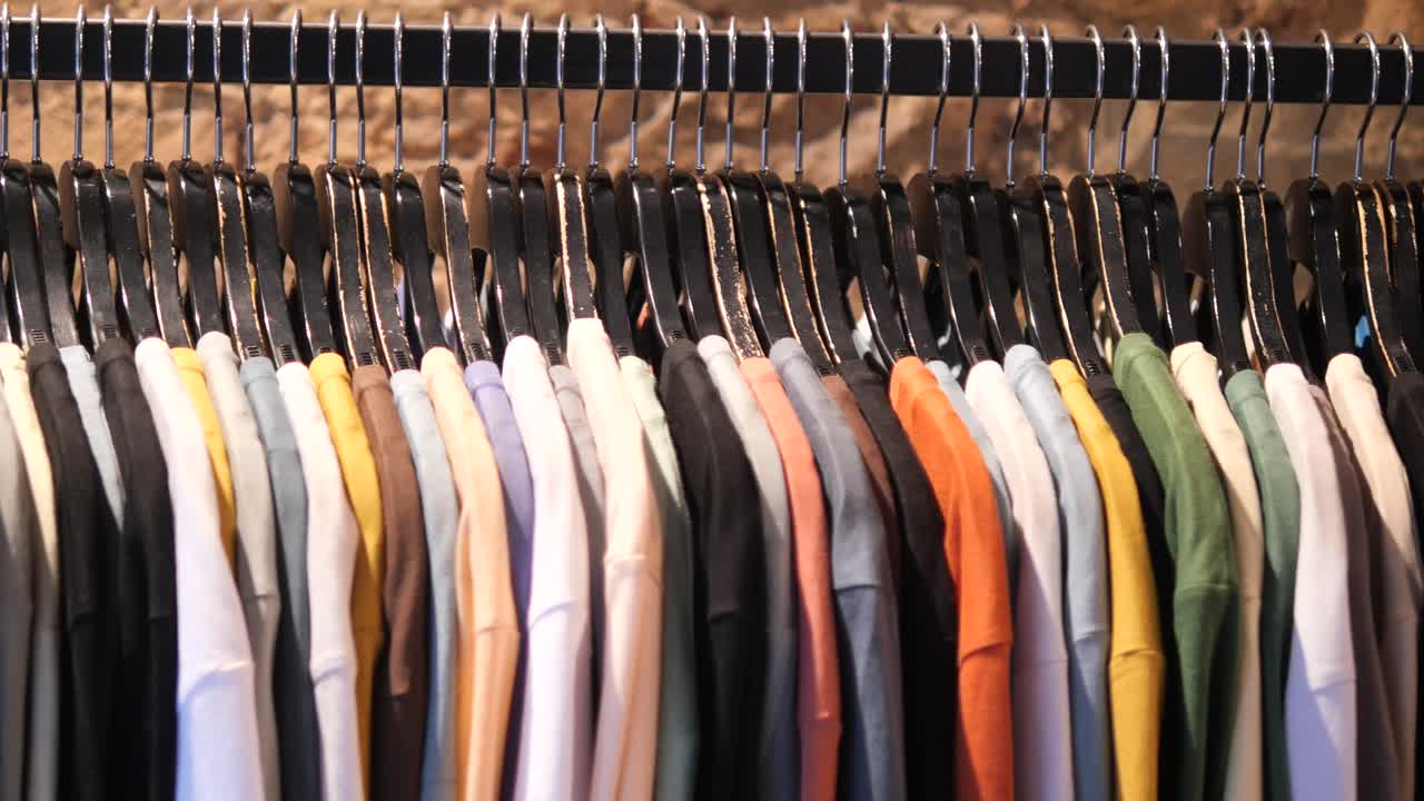 A rack of colorful shirts in a clothing store