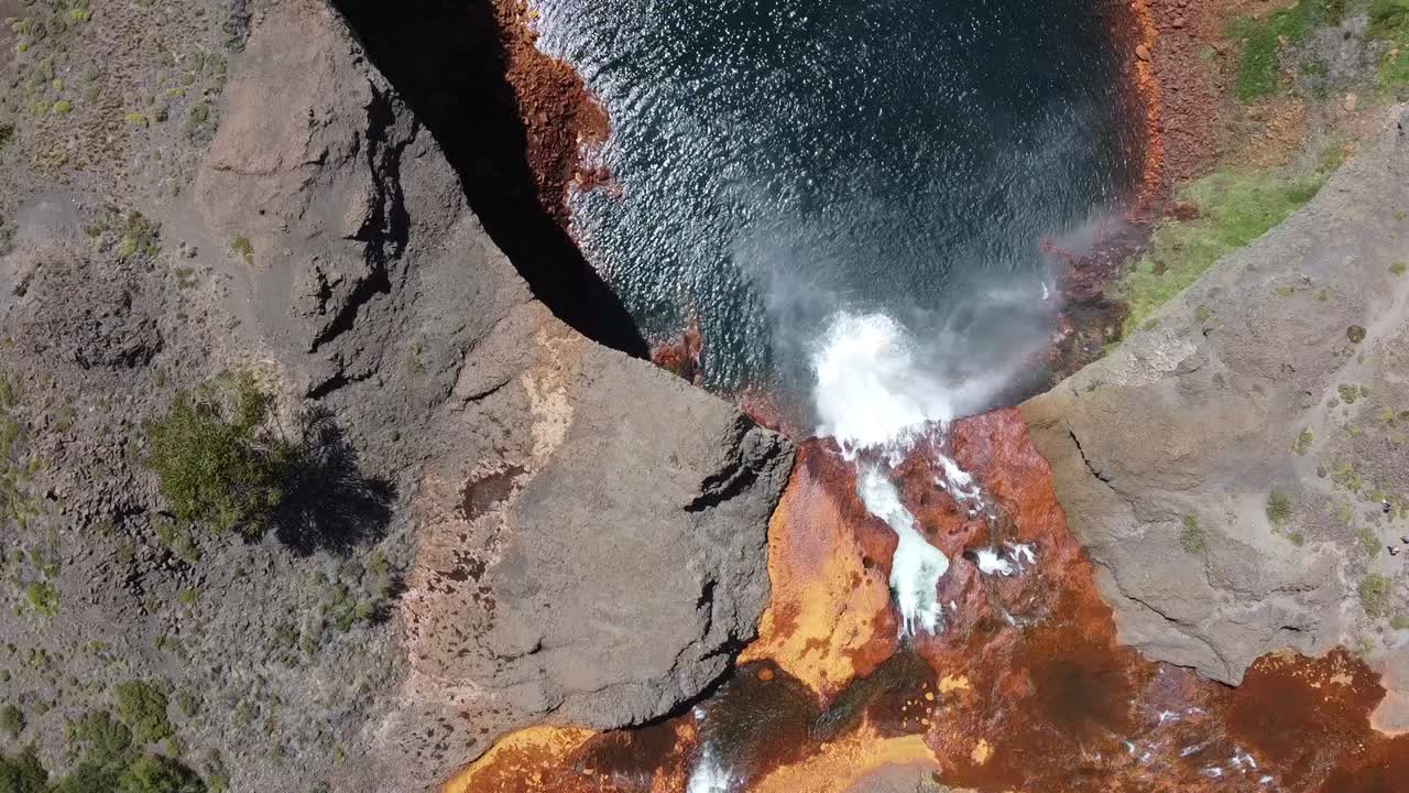 amazing waterfall with orange and blue colors as the acid water flows in Salto del Agrio in Argentina