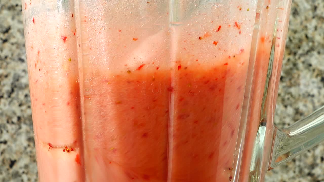 Preparazione di un cocktail nel frullatore con mele, banane e fragole