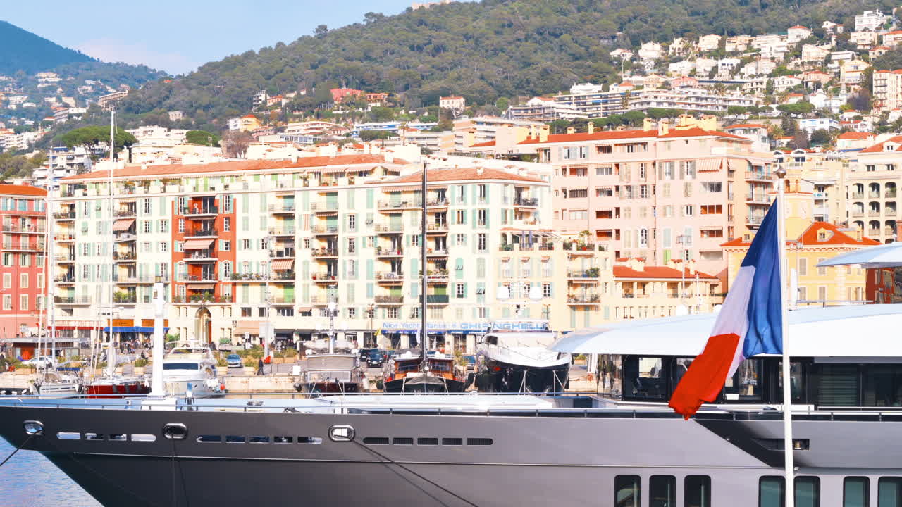 Barca bianca ormeggiata in un porto con vista sulla città di Nizza, Francia