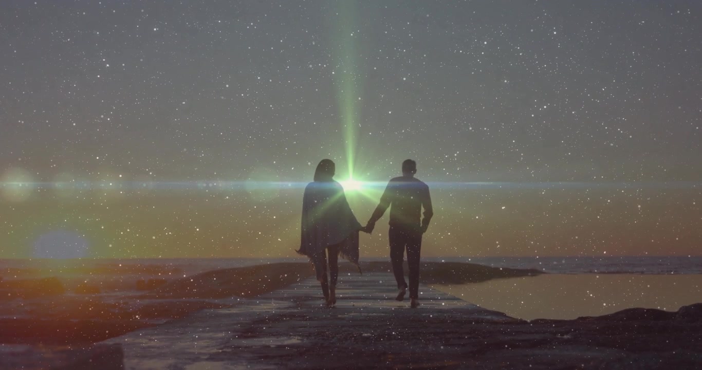 Casal caminhando no píer de mãos dadas, causando um reflexo de lente verde brilhante ao pôr do sol, para marketing de viagens.