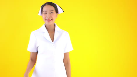 a young attractive asian woman in traditional nurses uniform pantomimes a knock and wave