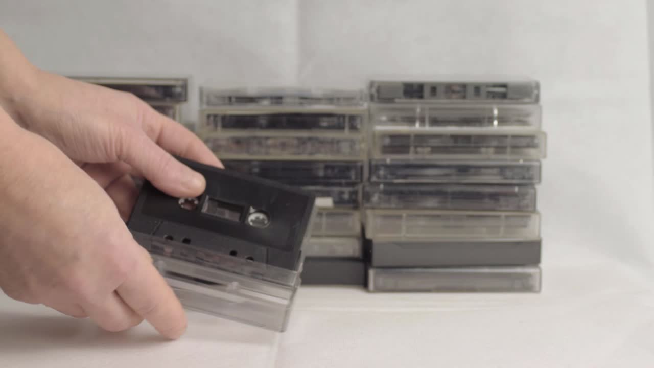 Hand looking through collection of retro cassette tapes