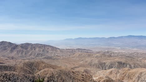 fixed shot of the arid desert terrain near joshua tree national park in palm springs, showing rocky hills and sparse vegetation