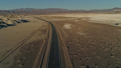 high aerial view pulling away from an empty highway in the desert