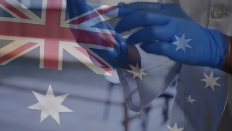 mid section of male doctor wearing surgical gloves against waiving new zealand flag