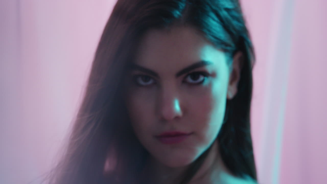 fantasía multicolor mujer joven hermosa buscando seductora entre las sábanas sensual belleza femenina cortinas soplando en un fondo colorido