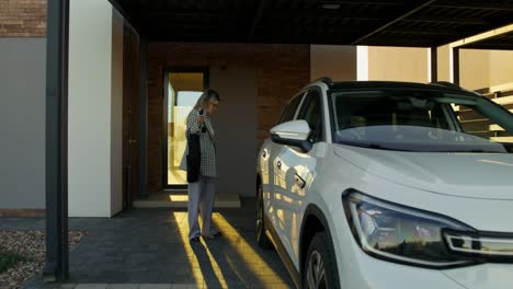 woman charging electric vehicle at home