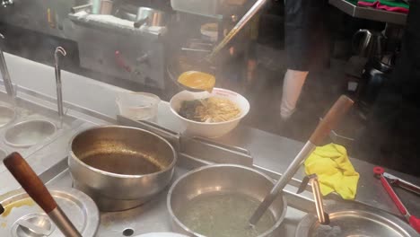 chef preparing noodle dish in a kitchen