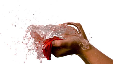 mujer haciendo estallar un globo de agua roja