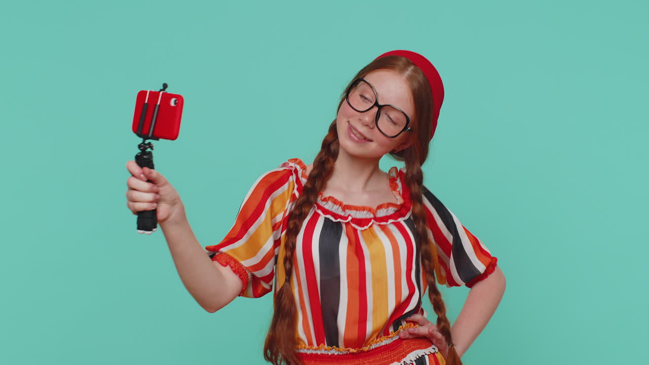 blogger adulta tomando selfies en el teléfono móvil, comunicándose en video llamada en línea con los suscriptores