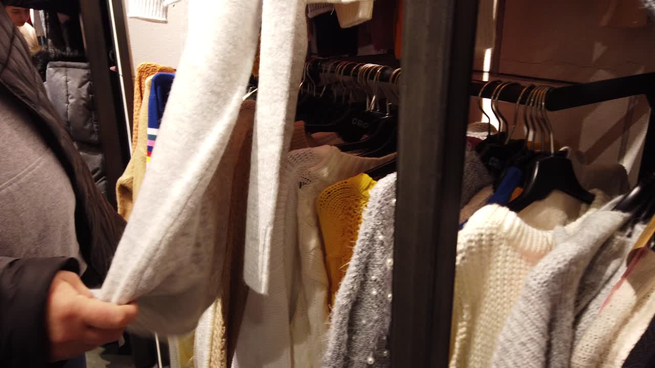 L'acquirente sceglie un maglione nel centro commerciale.
