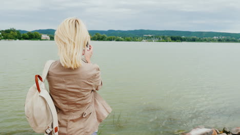 woman takes panorama of lake