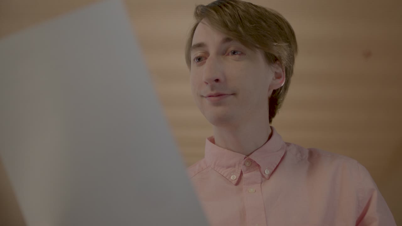 ботаник офисный работник поднимает документ и улыбается затем выглядит удивленным, статическим близко