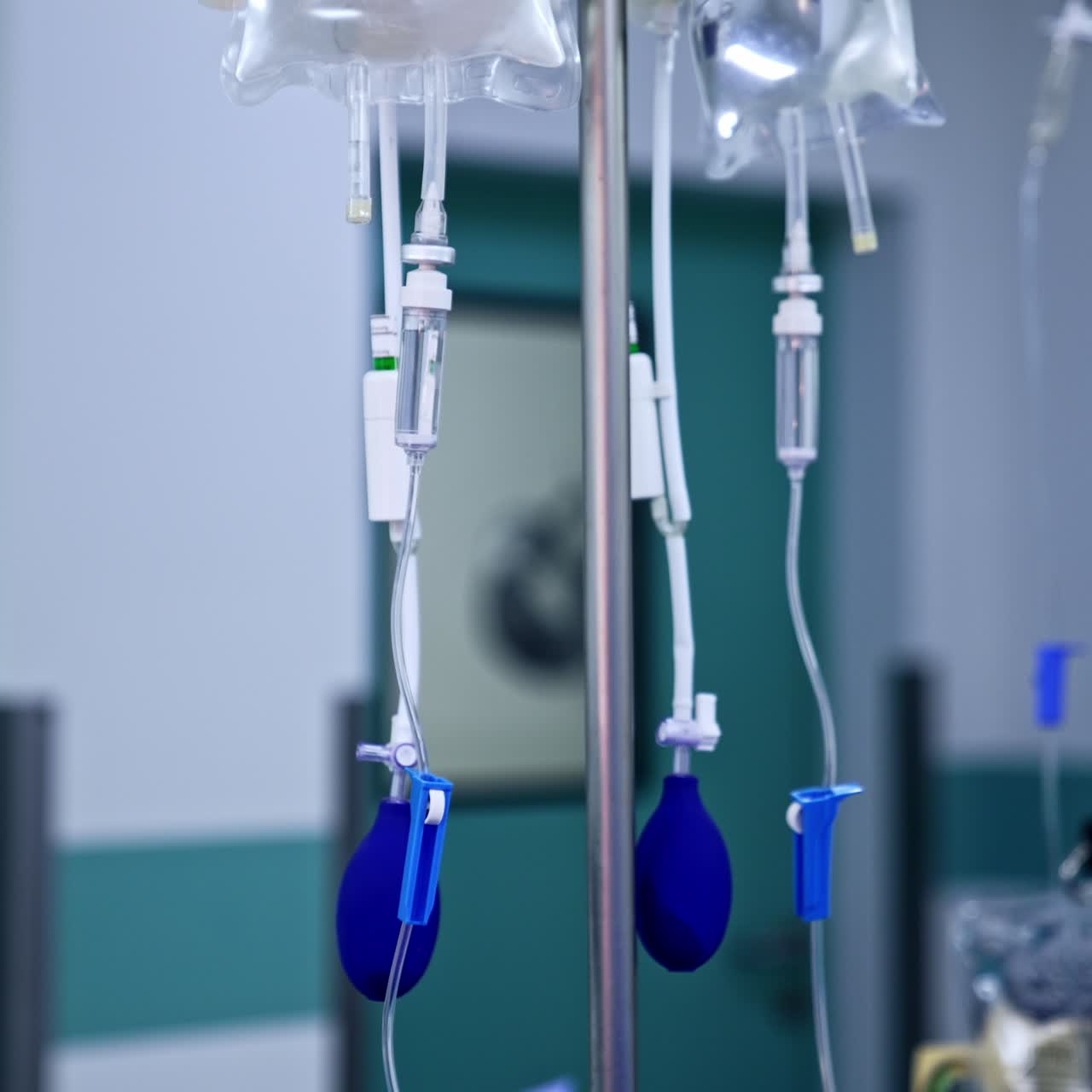 Blue pear pumps hanging from the drop counter stand. Equipment in surgery room. Blurred backdrop