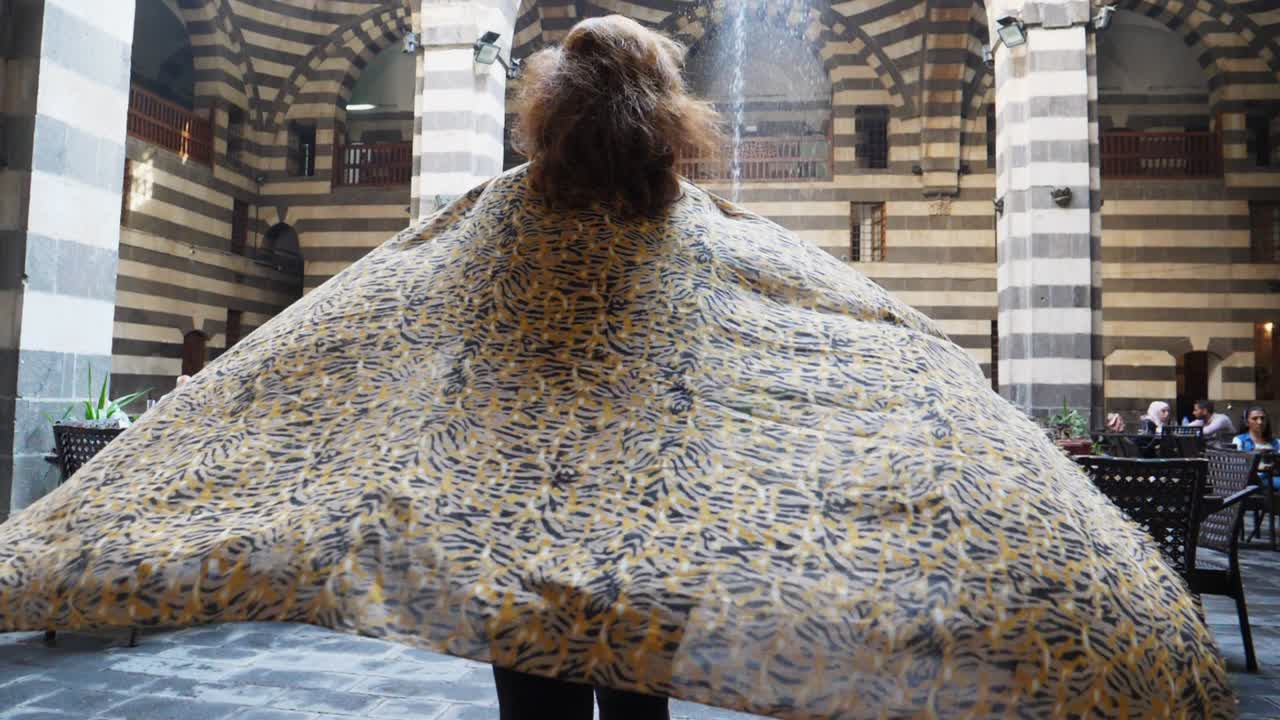 바람에 날리는 여성의 화려한 옷을 보여주는 상향 이동 샷