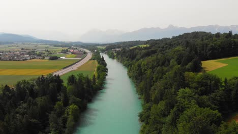 Aerial-of-a-river-surrounded-by-forest-and-hills