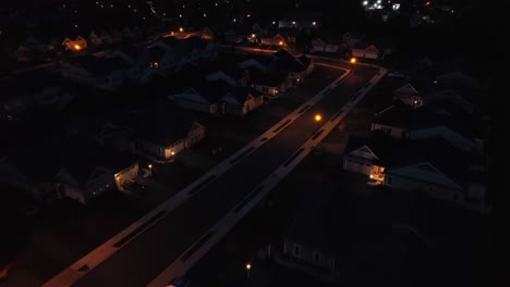 calle suburbana débilmente iluminada en un vecindario tranquilo por la noche