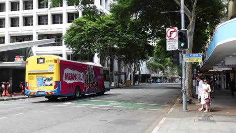 a colorful bus moves across an urban crosswalk