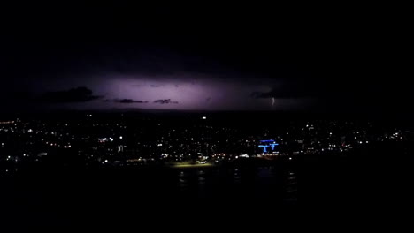 toma épica aérea en tiempo real de una tormenta eléctrica explosiva sobre una ciudad por la noche