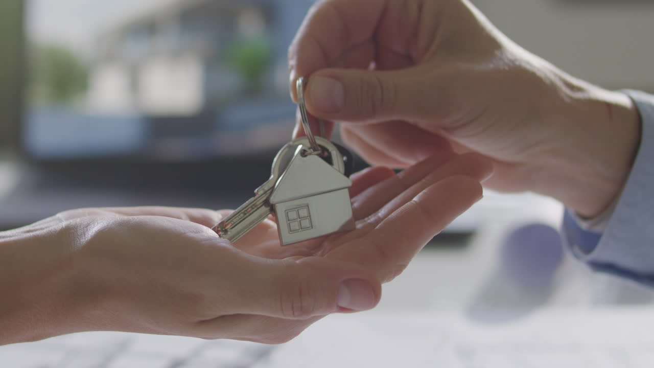 Hand of Real Estate Agent Passing Keys to Client during Property Deal
