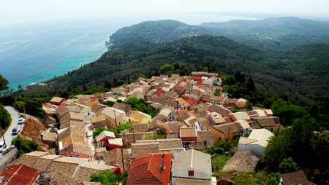 Aerial-drone-shot-over-old-Greek-mountain-village-of-Lakones-in-Corfu-surrounded-in-green-lush-vegetation